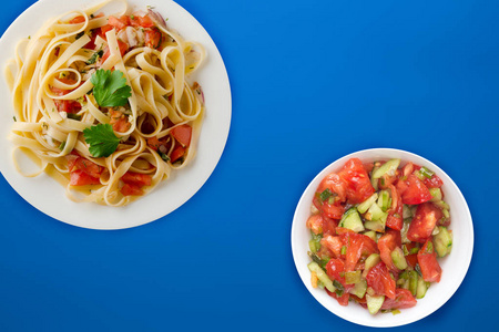 spaghetti on a white plate. spaghetti tomatoes, onions, cabbage 