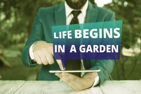 显示生命从花园开始的文字符号。概念图农业植物对园艺越来越热爱，手指放在他面前。
