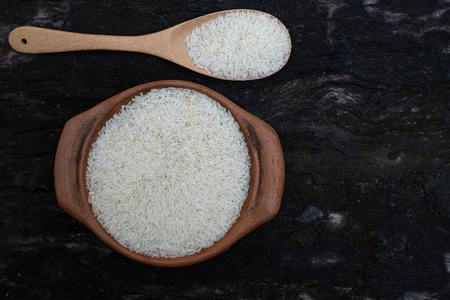 Jasmine rice in a clay pot and the wood ladle 