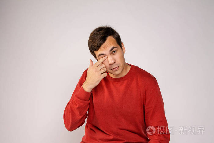 一个穿红毛衣的年轻人在哭在擦眼泪