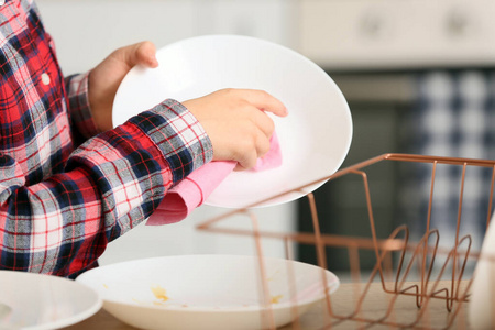 小男孩在厨房擦干净的盘子,特写照片