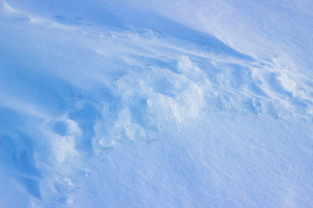 冬季自然背景下有积雪。蓝色色调的清新雪纹理背景。雪纹理的高角度视图，背景有复制空间。