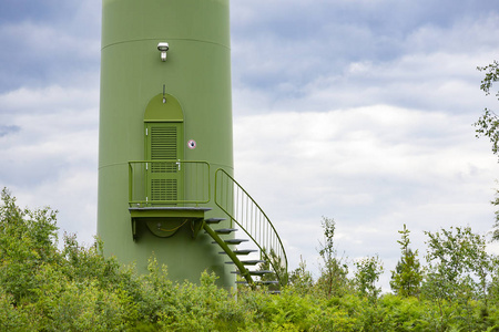 绿色风力发电厂风力发电厂风力发电厂的入口，在多云的森林里。绿色能源