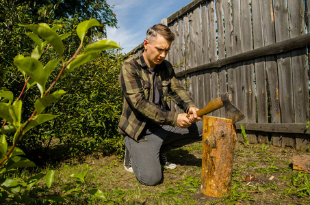 年轻人用斧头砍树照片