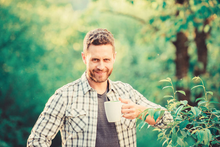 喝杯茶的快乐男人。早上咖啡。健康的生活方式。自然与健康。早餐茶点时间。人类的生态生活。绿林中的人。在户外喝茶。多么美好的早晨啊