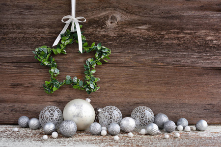 Christmas star with christmas balls on wooden background. 