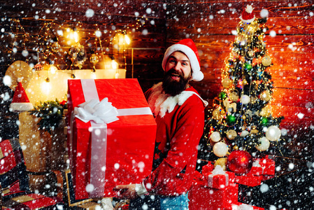 送礼物。礼物情感。穿着红色圣诞帽的时髦人士拿着礼物。圣诞老人祝圣诞快乐，新年快乐。