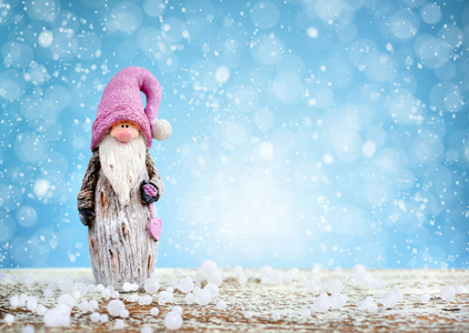 Cute gnome on festive blue background with snow. 