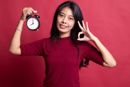 一个年轻的亚洲女人拿着一个钟就可以了。