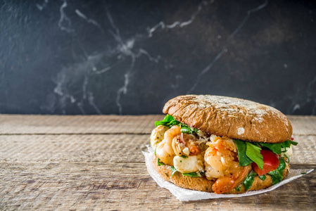 仿古木制的桌子上虾三明治各种海鲜和鱼汉堡油炸虾卷虾仁三明治美味烤