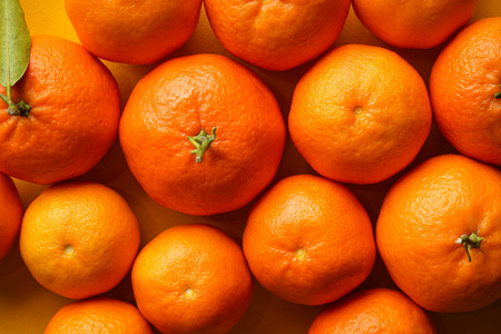 橙色橘子黄色背景特写。