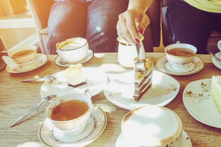 下午休闲快乐的女性朋友们下午在咖啡厅聚会,一起喝茶或喝咖啡,吃蛋糕