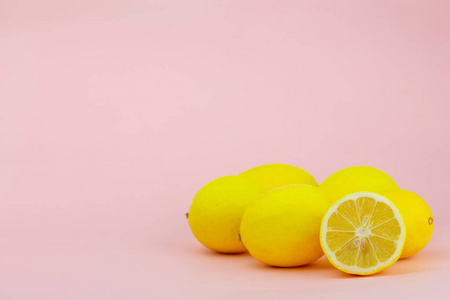 粉红色背景的成熟黄色柠檬