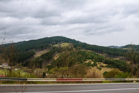 Empty winding road through forests in mountains.