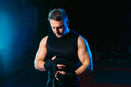 有魅力的男人用拳击手胶带包住他的双手-格斗,运动和拳击主题照片