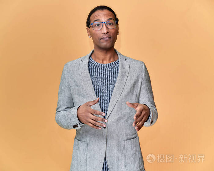 一位年轻的非洲裔美国人的肖像,短发,白牙微笑,穿着粉色背景的灰色