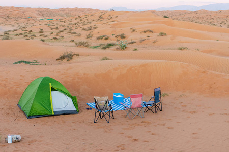 上的娱乐在阿拉伯联合酋长国沙漠的沙丘上,一个家庭露营的绿色帐篷