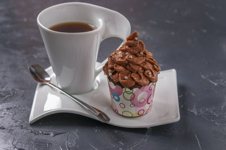 自制巧克力蛋糕，奶油和一杯咖啡放在黑暗的背景上，水平方向