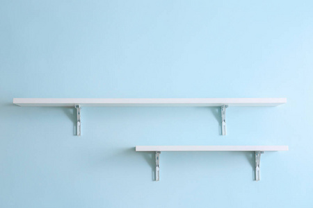 Empty shelves hanging on color wall