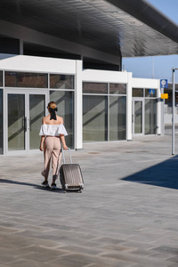 Elegant young woman with luggage at a train station. tourism con