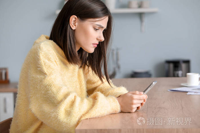 家里拿着手机忧心忡忡的年轻女子