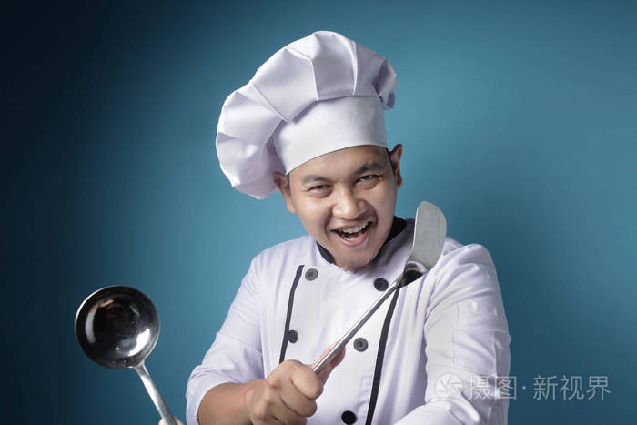 功夫厨师男亚洲厨师拿着勺子和抹刀准备好了