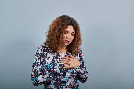 光荣说话病发黑发年轻女子双手捂胸,神情失望照片