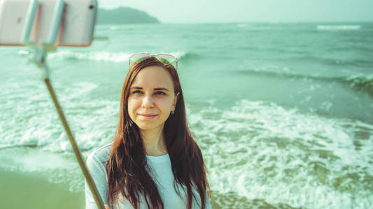 快乐的女人在海边自拍。从上面高兴的女人用