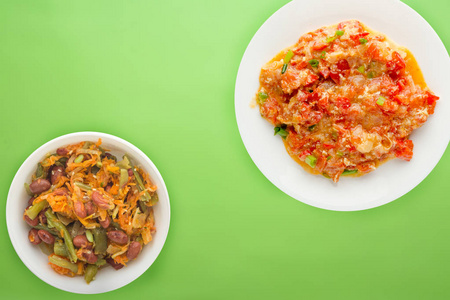  Stewed tomatoes with onions in a white  plate on a colored back