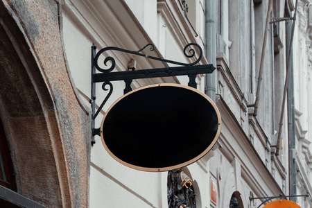 黑色古董店招牌模型。欧洲小镇古墙上的空商店街标志