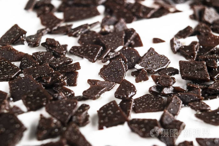 白色背景上孤立的一堆碎巧克力.碎黑巧克力分离在白色.