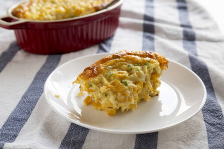 Tasty Homemade Cheddar Corn Pudding Casserole on a white plate, 