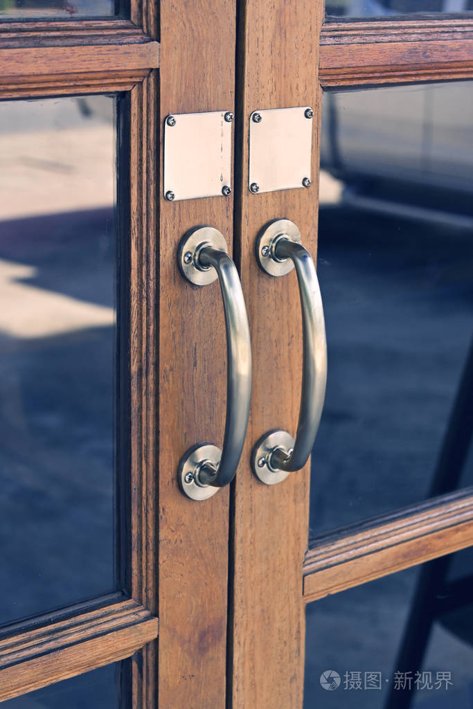 古董门上的铜把手用玻璃和旧木头设计门廊