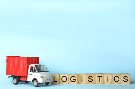 浅蓝色背景上有单词LOGISTICS的玩具卡车和立方体