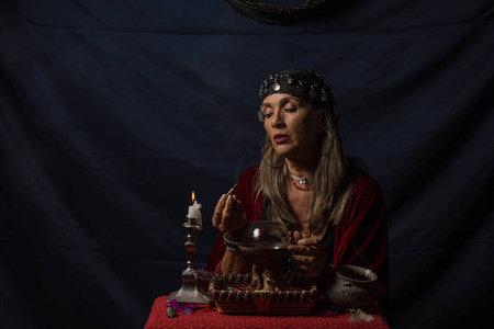 吉普赛占卜师或手持冒烟木头的神秘预言家神秘女孩穿黑色,马穿木头.