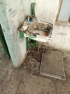 中亚街道上非常脏的旧水槽和水龙头