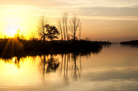  Landscape. Sunset over the lake, fall trees reflected in water.