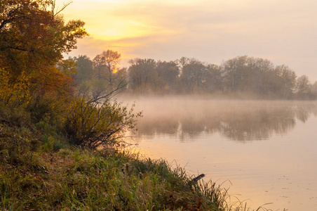  Landscape. Sunset over the lake, fall trees reflected in water.