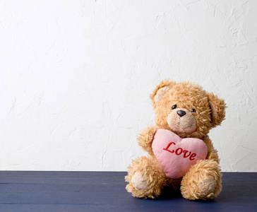 cute brown teddy bear holding a big pink heart 