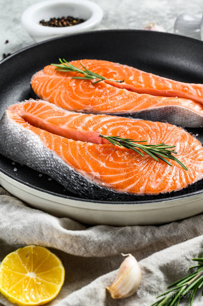 新鲜三文鱼排在平底锅里健康的海鲜灰色背景俯视图