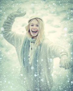 冬天快乐。可爱俏皮的年轻女子在户外享受初雪。冬天快乐女人的画像。户外快乐的女孩。