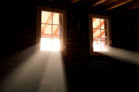 木屋地下室的窗户.光束穿过它们照片