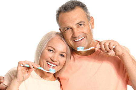 成年夫妇在白色背景上刷牙