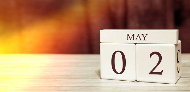 日历提醒事件概念。5月2日阳光下的数字和月份的木块。