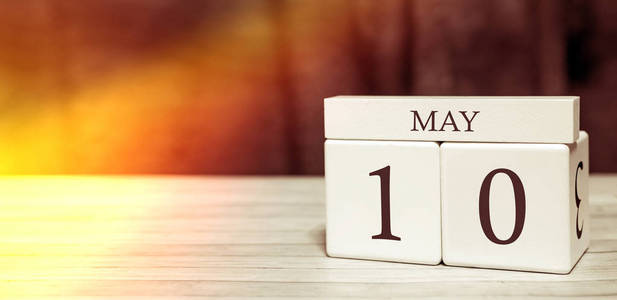 日历提醒事件概念。5月10日阳光下的数字和月份的木块。
