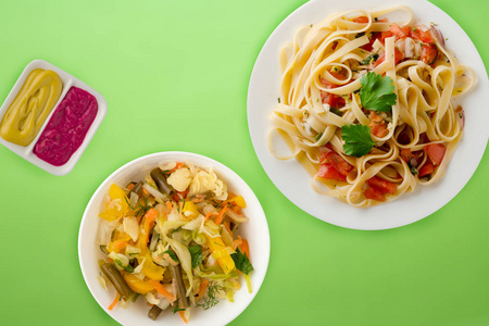 spaghetti on a white plate. spaghetti tomatoes, onions, cabbage 