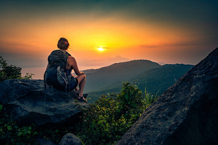 Young woman admire beautiful sunset over The Da Nang Bay and Ba 