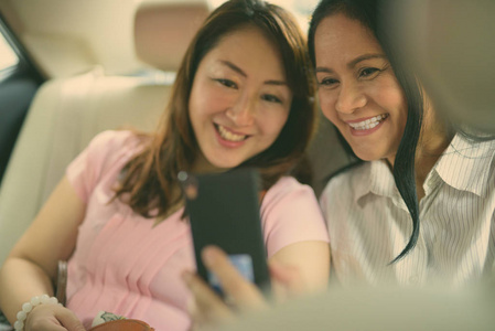 两个成熟的亚洲女人一起坐在车里