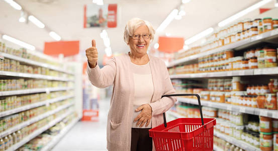 Elderly woman with a shopping basket in a supermarket 