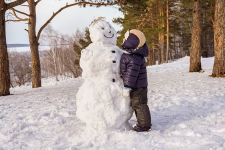 儿童手套冬季小男孩在冬天玩雪人.冬季与孩子们一起积极户外休闲.